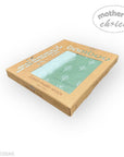 Box of bamboo muslin wraps with a green pattern on a white background