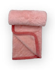 Folded pink fleece blanket on a white background