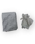 Gray textured blanket and elephant-shaped soft toy on a white background
