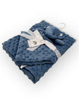 Blue textured blanket with a plush elephant toy on a white background