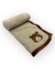 Folded blanket with a teddy bear design on a white background