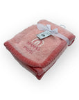 Pink plush blanket with 'Mama's girl' text and a tag on a white background
