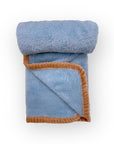 Folded blue blanket with brown trim on a white background