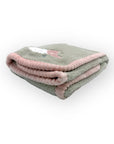 Folded gray blanket with pink trim on a white background