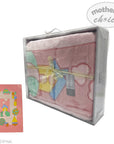 Pink baby blanket with colorful toy design in packaging on a white background