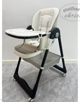 Child's high chair with tray on a gray floor, branded 'Mother's Choice'.