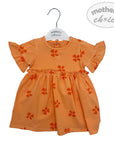 Orange dress with floral patterns on a hanger against a white background