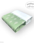 Folded green fabric with white leaf pattern on a white background, branded 'mother's choice'.