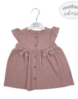 Pink baby dress with bows on a hanger against a white background
