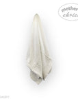 Light gray towel hanging on a white wall with 'mother's choice' branding.
