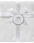 White baby shawl with a bow and 'Mother's Choice' label on a white background
