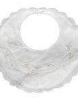 White bib with delicate floral embroidery on a white background