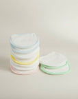 Stack of colorful baby bibs on a light background