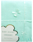 Mint green baby shawl with a bow on a light blue background