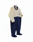 Children's outfit with a cream cardigan and navy polka dot pants on a white background