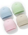 Four pastel-colored baby hats on a white background