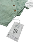 Green baby blanket with buttons and a 'mother's choice' tag on a white background