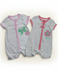 Two baby rompers with floral designs on a white background