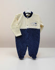 Baby outfit with cream top and navy polka dot pants on a white background