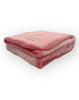 Folded pink blanket on a white background