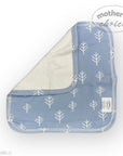 Baby bib with blue and white tree pattern on a white background