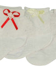 Three pairs of baby socks with decorative bows on a white background