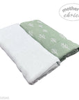 Two folded towels, one white and one green with leaf pattern, on a white background. 'Mother's Choice' logo visible.