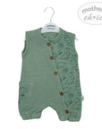 Green baby romper with dinosaur patterns on a hanger against a white background