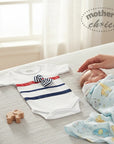 Mother's Choice white cotton romper with navy and red stripes and a bow, next to a sleeping baby.