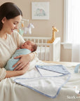Stork And Baby blue bamboo hooded baby towel with white trim and star pattern, laid out next to a gift box.