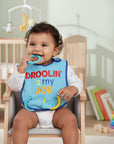 Stork And Baby blue bib with "Droolin Is My Job" text and attached teething rings for babies.