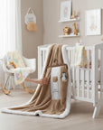 Stork And Baby brown sherpa fleece baby blanket with white trim and embroidered penguin and bear details.