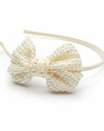 Stork And Baby cream girls alice band featuring a ribbon bow embellished with pearls and sparkling diamantes