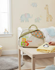 Stork And Baby 'Too Cool For School' diaper bag in cream with green trim, featuring alphabet blocks and playful text. Round top opening.