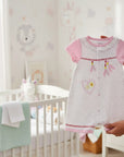 Stork And Baby white 100% cotton baby romper with pink sleeves and dream catcher detail.