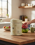 Stork And Baby embroidered bottle warmer in stone and brown with floral stitching, perfect for travel.