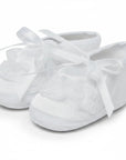 Stork And Baby Mothers Choice white christening booties for girls with delicate lace trim and satin ribbon ties.