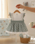 Stork And Baby green floral cotton linen baby dress with white eyelet bodice and lace trim. Ruffled sleeves.
