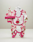 Stork And Baby pink floral 5-piece infant grower set with hat, bib, bodysuit, and mittens. Soft cotton.