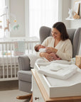 Stork And Baby Mothers Choice 100% cotton white receiving blanket folded on a nursery dresser with mother and baby