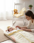 Stork And Baby Mothers Choice infant baby sac in soft cream, keeping a newborn cozy on a nursery floor.