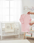 Stork And Baby Mothers Choice pink cotton baby sleeping bag with Born To Shop embroidery in a cozy nursery setting.