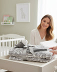Stork And Baby neutral baby blanket with a grey donkey plush toy, tied with a silver ribbon.