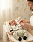 Stork And Baby newborn 5-piece starter pack in green with a bow print, including a babygrow, bib, and mittens.
