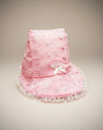 Stork And Baby pink infants anglaise hat with white lace trim and a small bow detail.