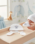 Stork And Baby white 100% cotton 3-piece infant set with embroidered bear and star detail on hat and booties.