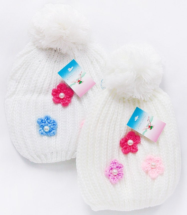 White knitted hats with colorful flower decorations on a white background