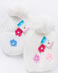 White knitted hats with colorful flower decorations on a white background