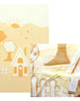 Baby blanket with cartoon design featuring a house, sun, and tree on a white background.