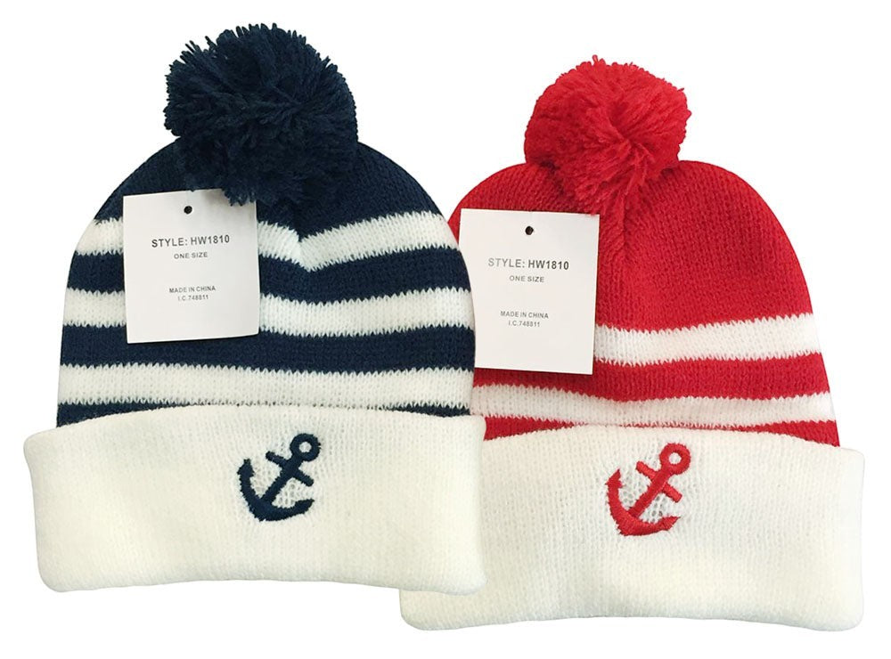 Two knit hats with pom-poms, one navy and white striped with an anchor, the other red and white with an anchor, on a white background.